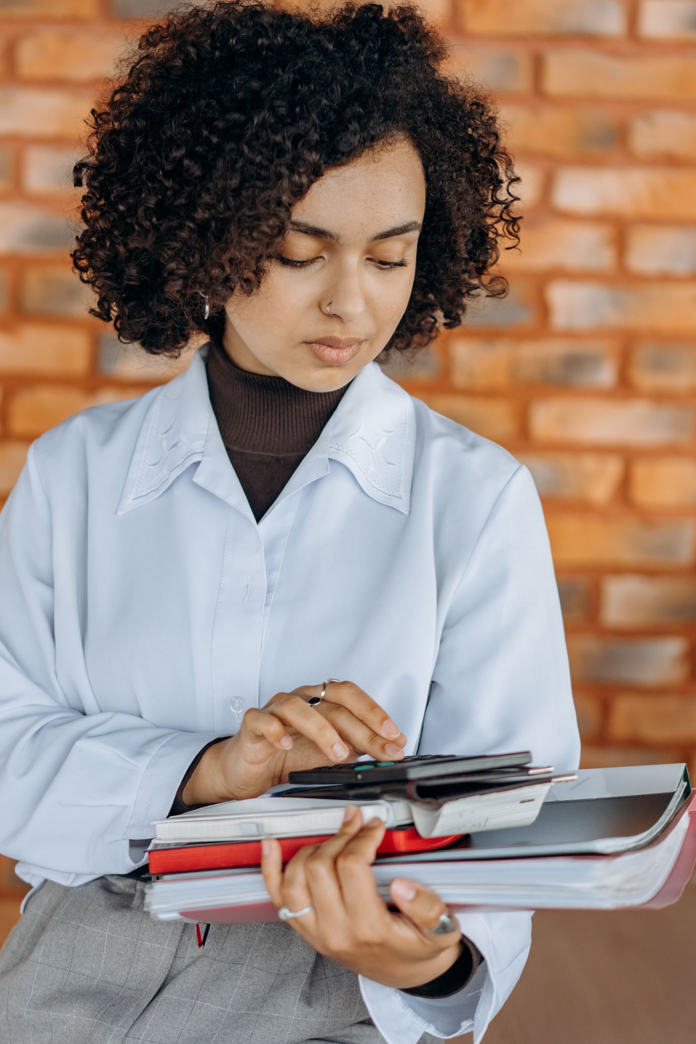 Nadia Okafor holding a stack of client folders, reading a figure