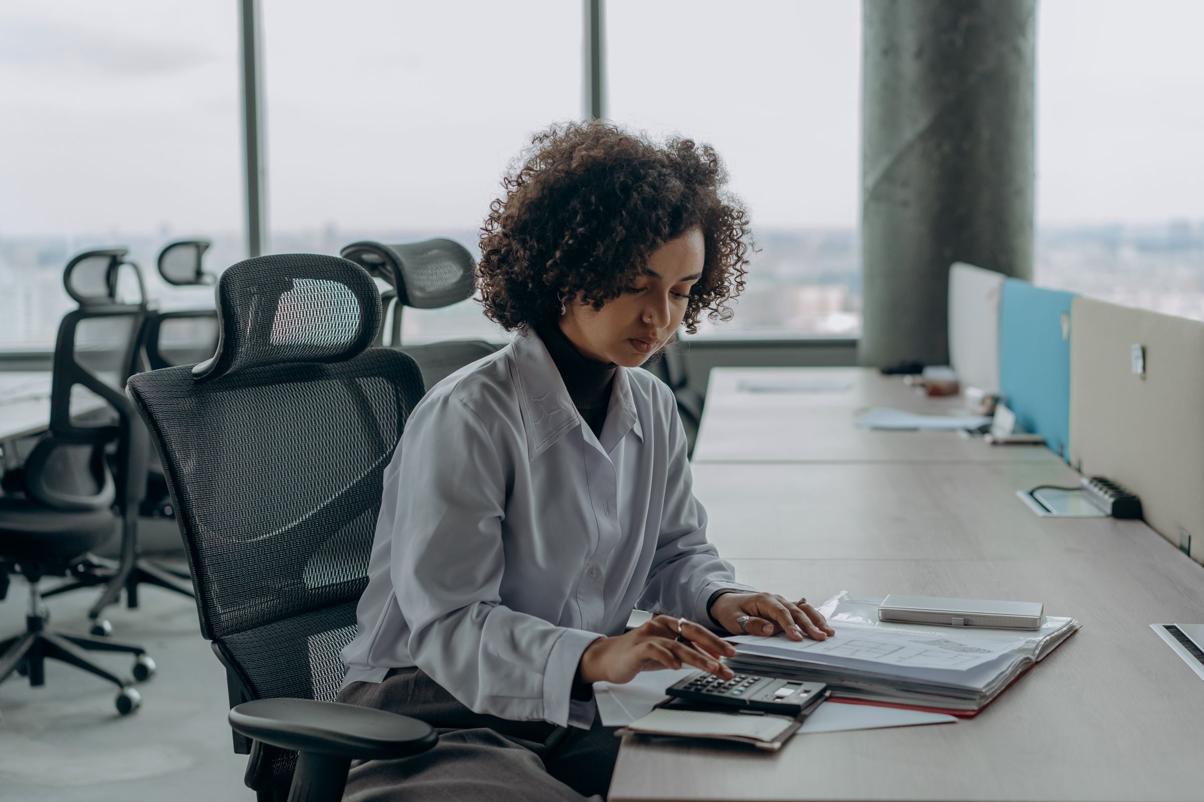 Nadia Okafor working at her desk in a high-rise office